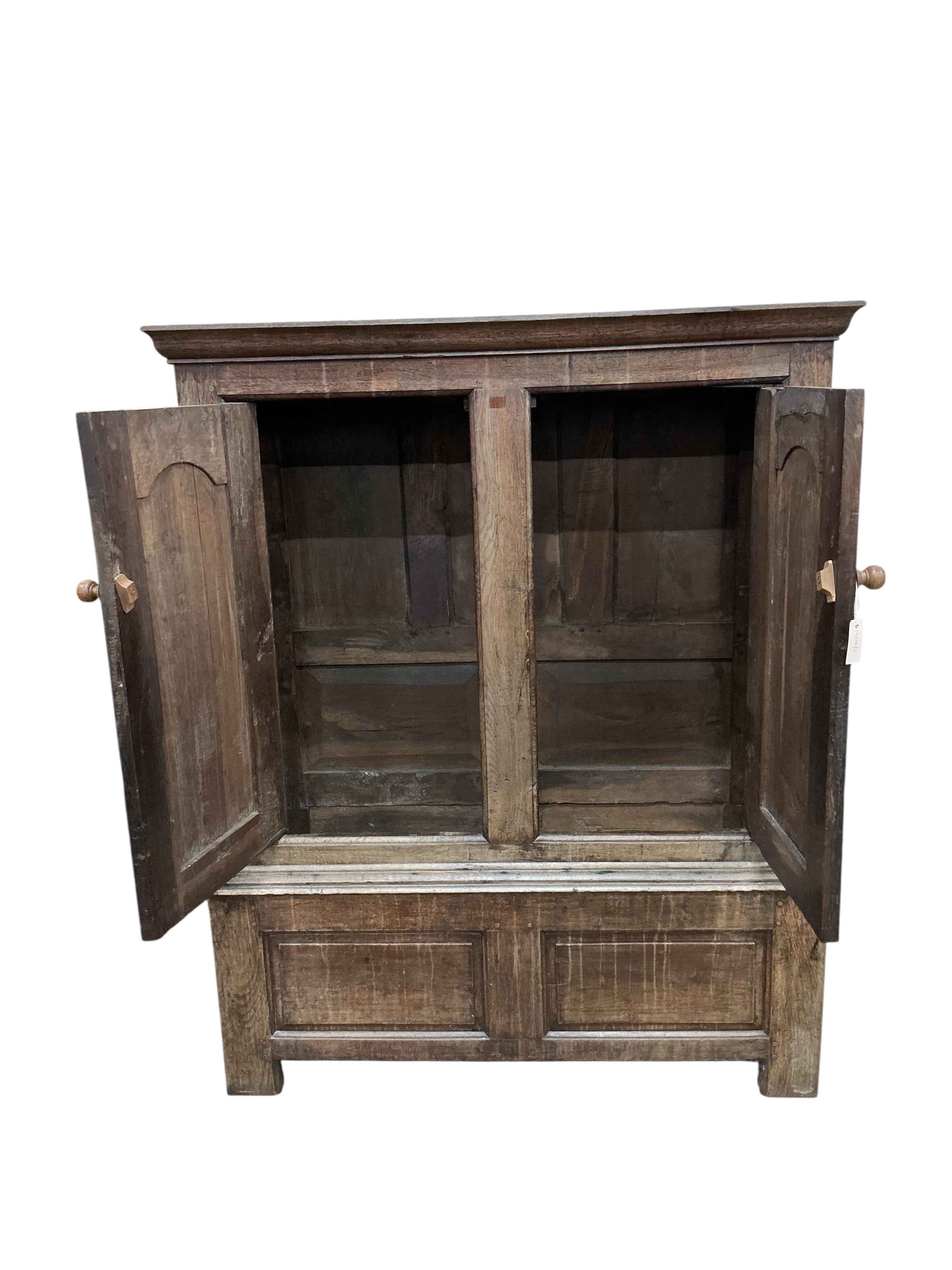 An 18th century oak hanging cupboard, width 131cm, depth 49cm, height 165cm